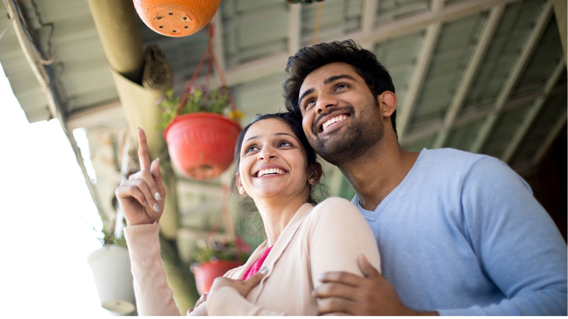 A smiling couple looking out together at a café